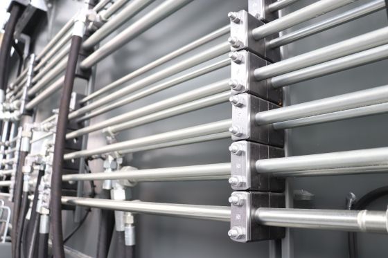 Pipes on a construction machine guided by clamps