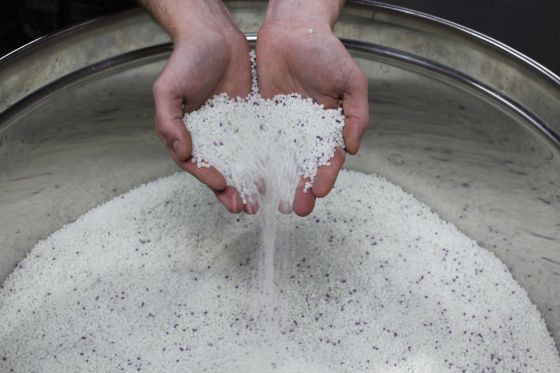 PP recyclate is scooped with two hands