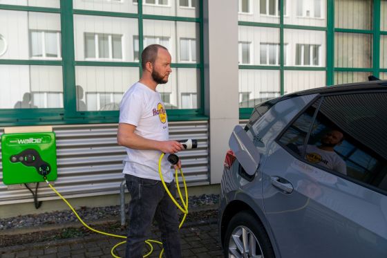 Le véhicule électrique STAUFF est branché à la station de recharge.
